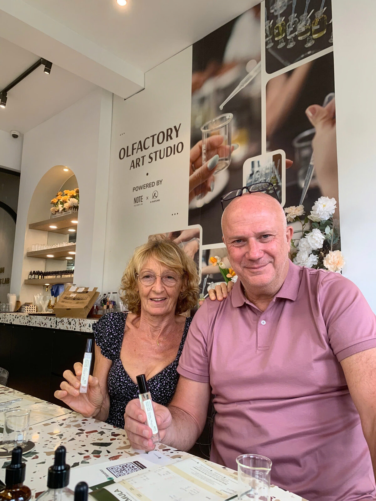 Couple showing custom perfume bottles after perfume making workshop experience