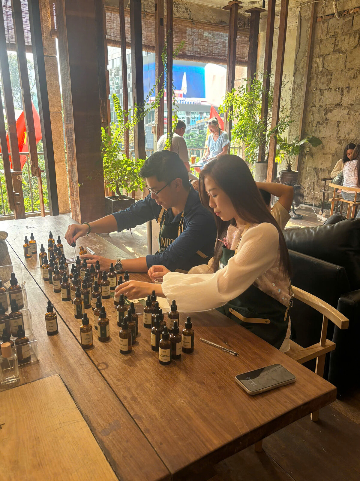 Solo woman blending custom fragrance ingredients at NOTE Thao Dien studio