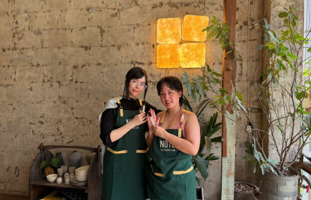 Visitors wearing NOTE aprons after completing perfume workshop at Cafe Apartment HCMC